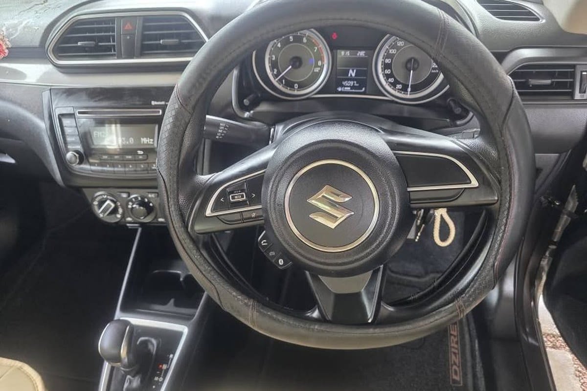Kabinen i Suzuki Dzire med automatgearvælger, instrumenter og betjening på rattet