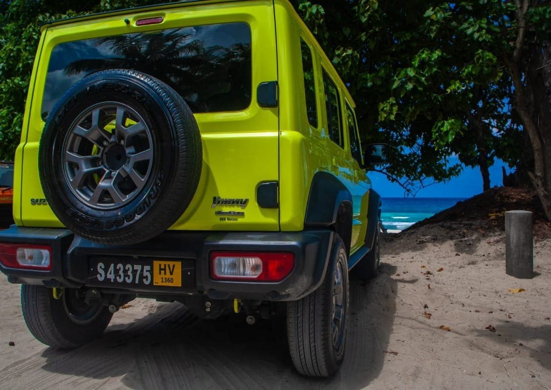 Bagenden af Suzuki Jimny med reservehjulet, i sandet