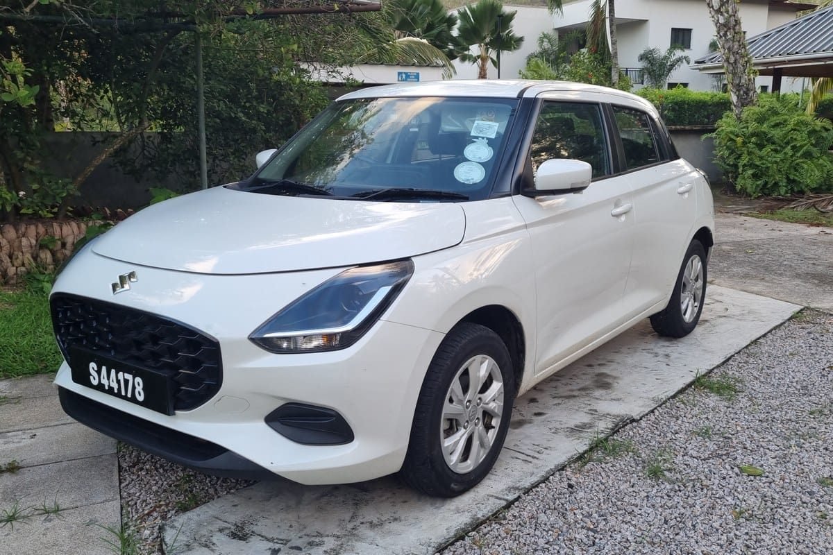 En hvid Suzuki Swift på en indkørsel på Mahé, set skråt forfra
